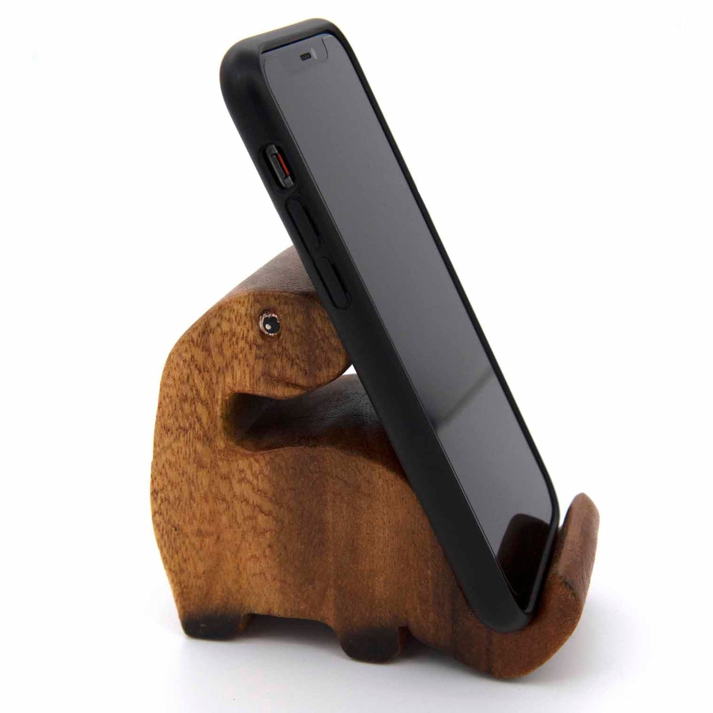 Carved wooden dinosaur phone stand with phone, front three-quarter view showing rounded body form, Thailand