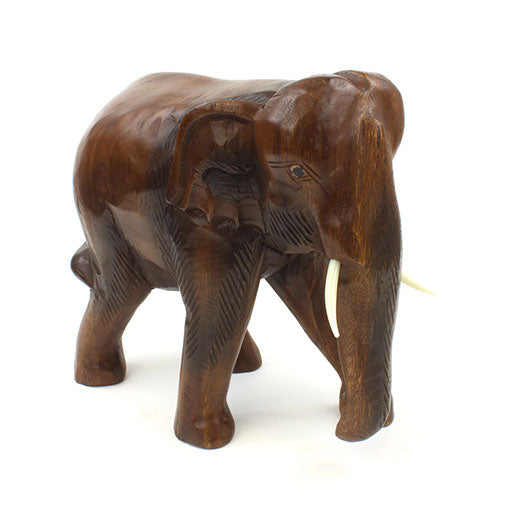 Large carved Raintree wood elephant, three-quarter front view showing broad head and tusks, white background