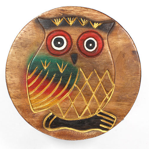 Top-down view of Raintree wood owl stool seat showing full carved owl with red eyes and gold-lined feather detail, Thailand