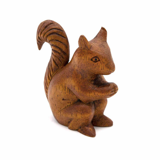 Amber-stained wood squirrel carving holding a nut, three-quarter view showing striped tail