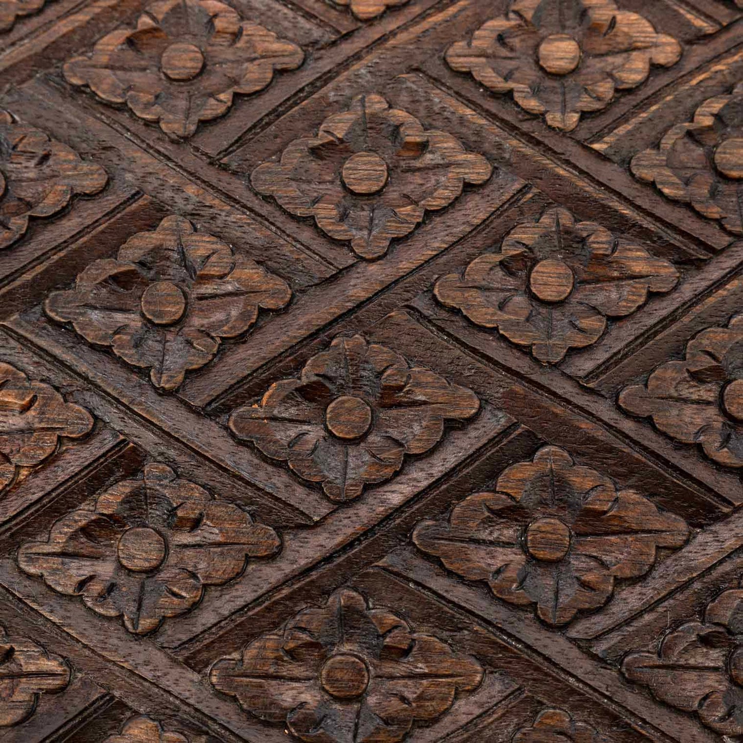Macro detail of diamond-and-flower relief carving on the lid of the Indonesian wooden jewellery chest