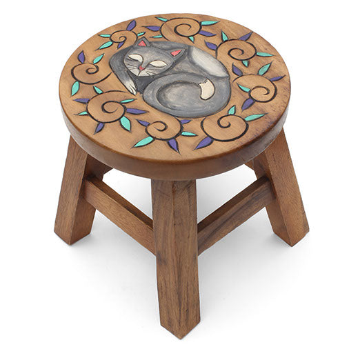 Hand-carved curled cat stool in Raintree wood, three-quarter view on white background showing scroll and leaf border detail