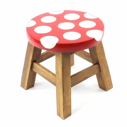 Hand-painted mushroom stool in Raintree wood on white background, red seat with large white spots and natural wood legs
