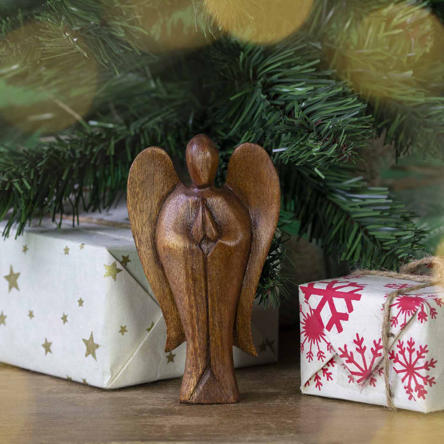Hand-carved Balinese abstract angel figurine displayed beneath a Christmas tree, Indonesia