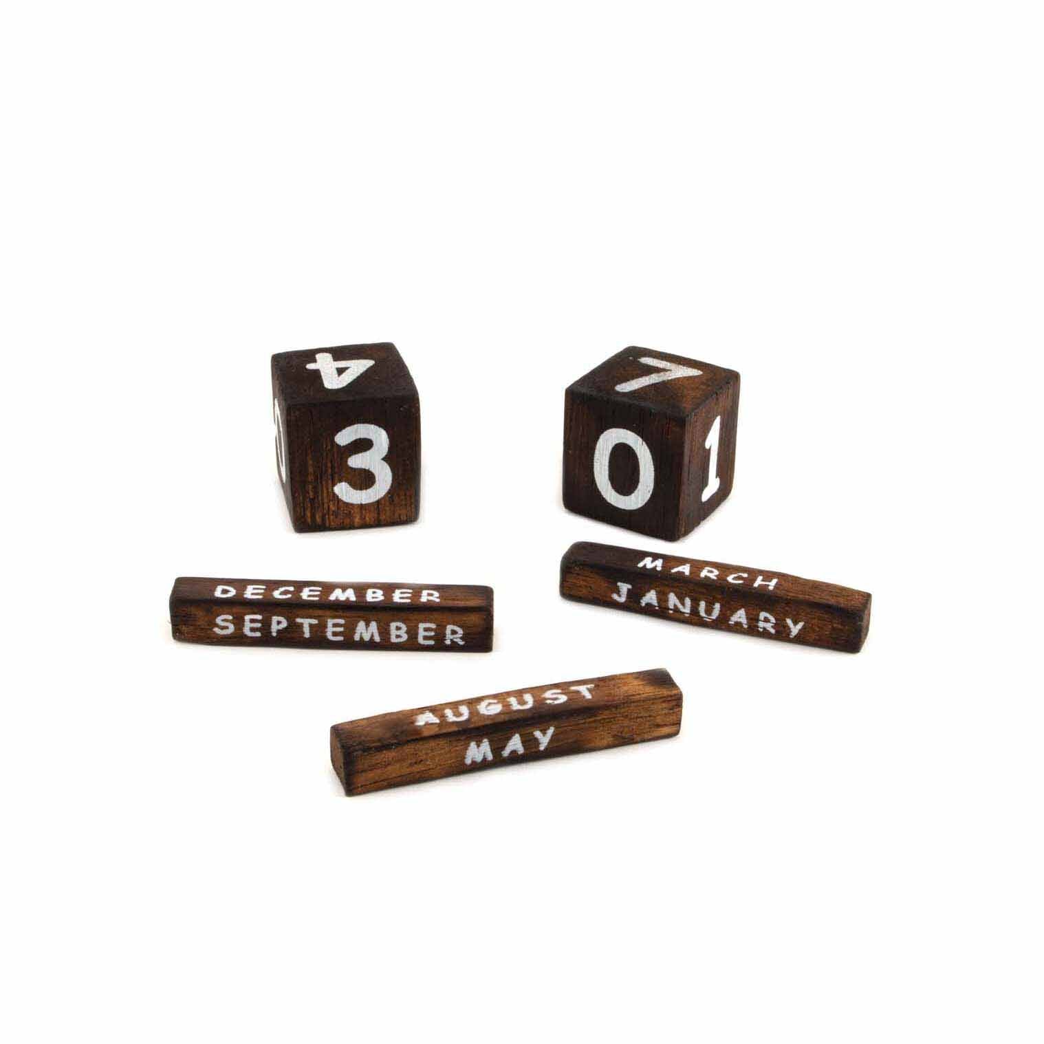 Dark wood date blocks and month bars from the elephant perpetual calendar, removed and laid flat