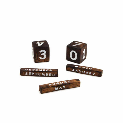 Dark wood date blocks and month bars from the elephant perpetual calendar, removed and laid flat