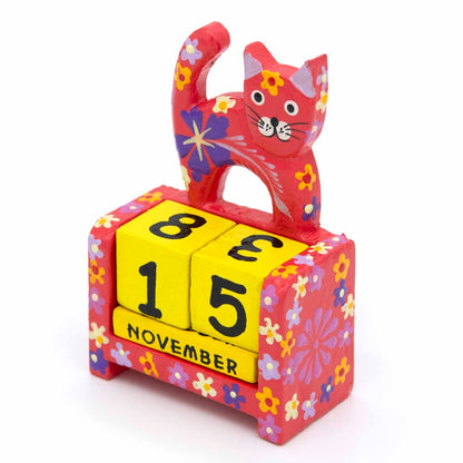 Red painted wooden cat calendar with yellow date blocks showing November, front view on white