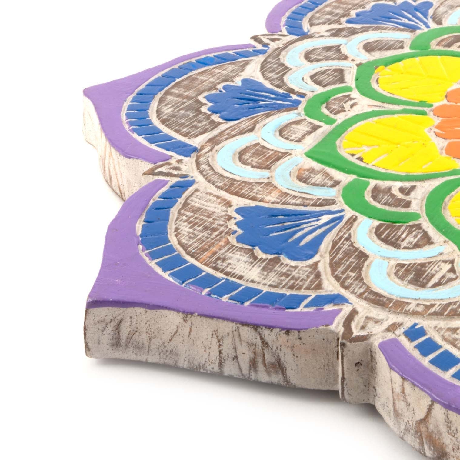 Close-up of carved albesia wood edge showing raw grain finish and relief-carved petal detail on Bali mandala plaque