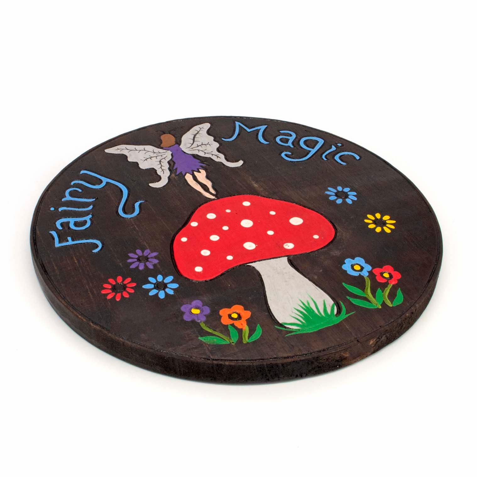 Angled side view of Fairy Magic round wood plaque showing disc depth and painted edge, Indonesia