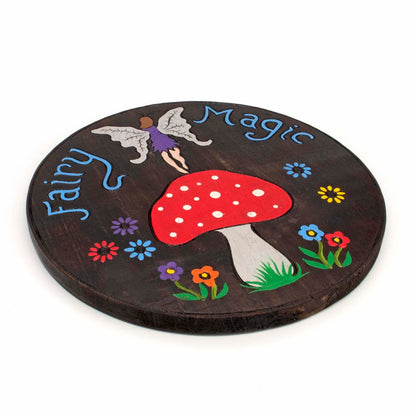 Angled side view of Fairy Magic round wood plaque showing disc depth and painted edge, Indonesia