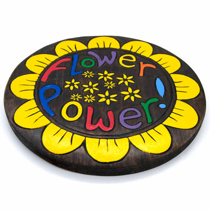 Angled side view of Flower Power round wood plaque showing disc depth and yellow-painted petal edge, Indonesia