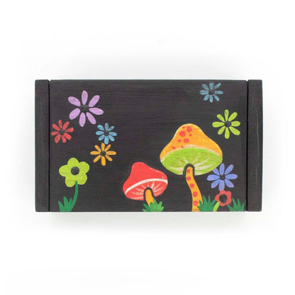 Top-down view of black wooden box lid showing toadstool and daisy painting, Indonesia