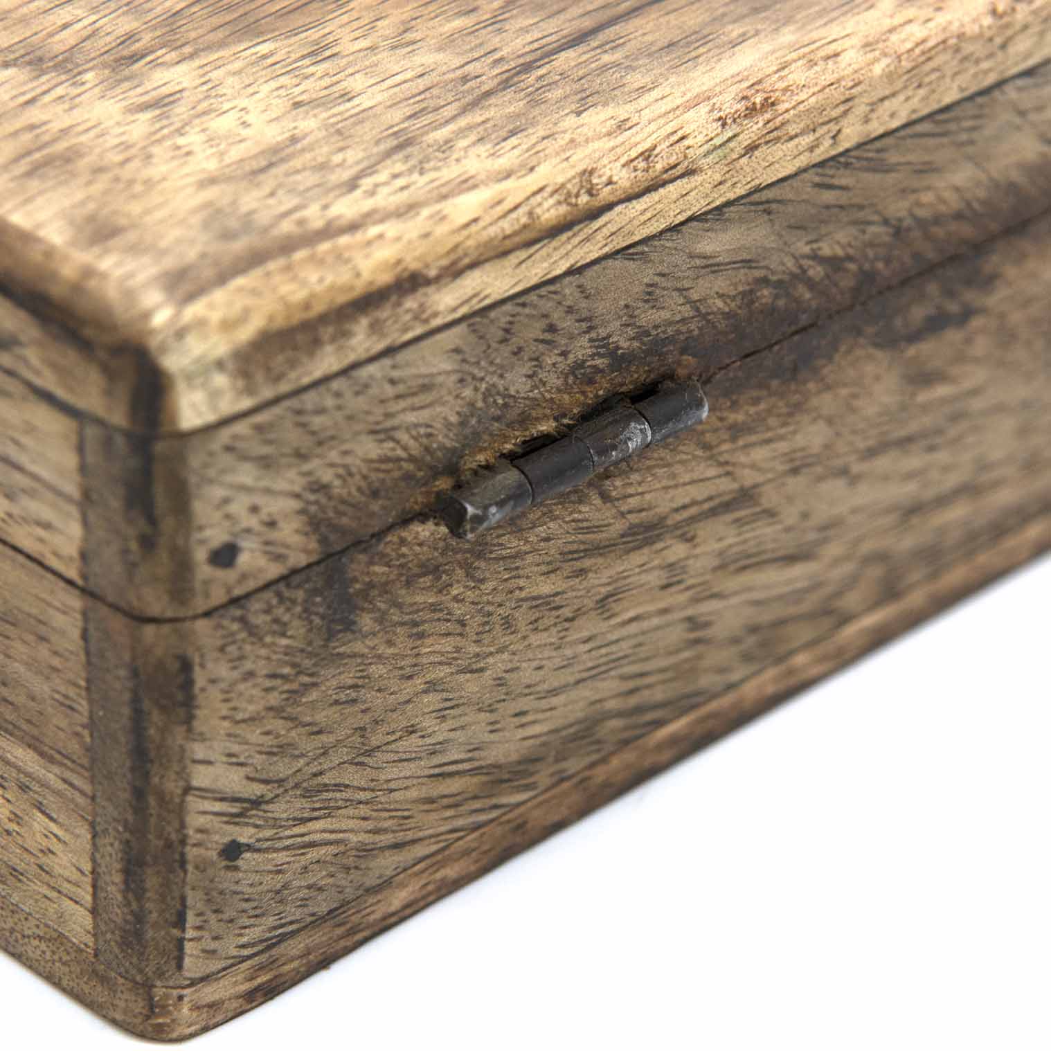 Close-up of metal hinge on mango wood Celtic cross box, showing grain texture