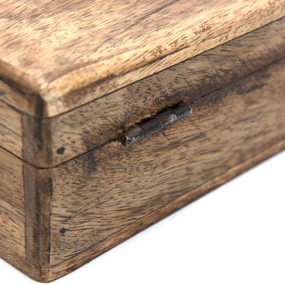 Close-up of metal hinge on mango wood Celtic cross box, showing grain texture