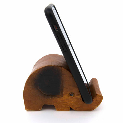 Carved elephant phone stand holding a smartphone upright, side view showing trunk slot, white background
