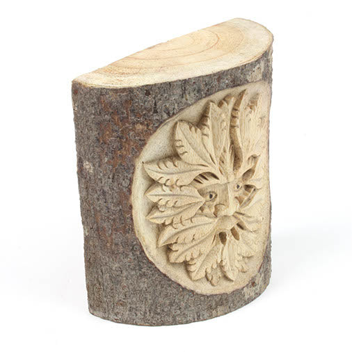 Side view of Green Man white wood trunk carving showing the half-section profile and bark texture