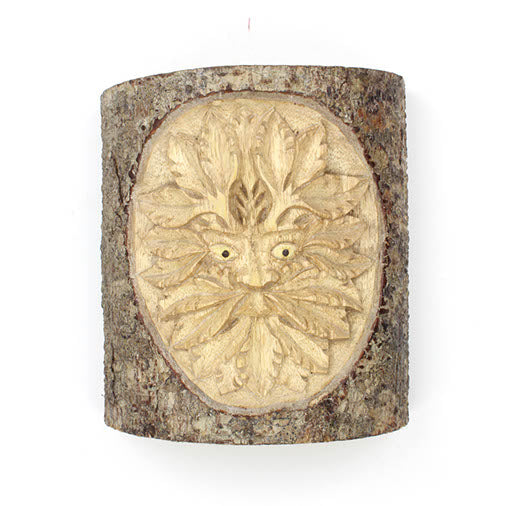 Front-on view of Green Man trunk carving, Indonesia, showing oval leaf relief and bark surround against white background