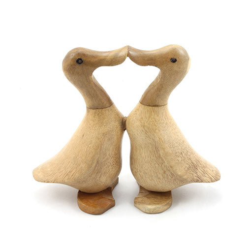 Two carved bamboo root ducks facing each other beak to beak, natural unvarnished finish, front view