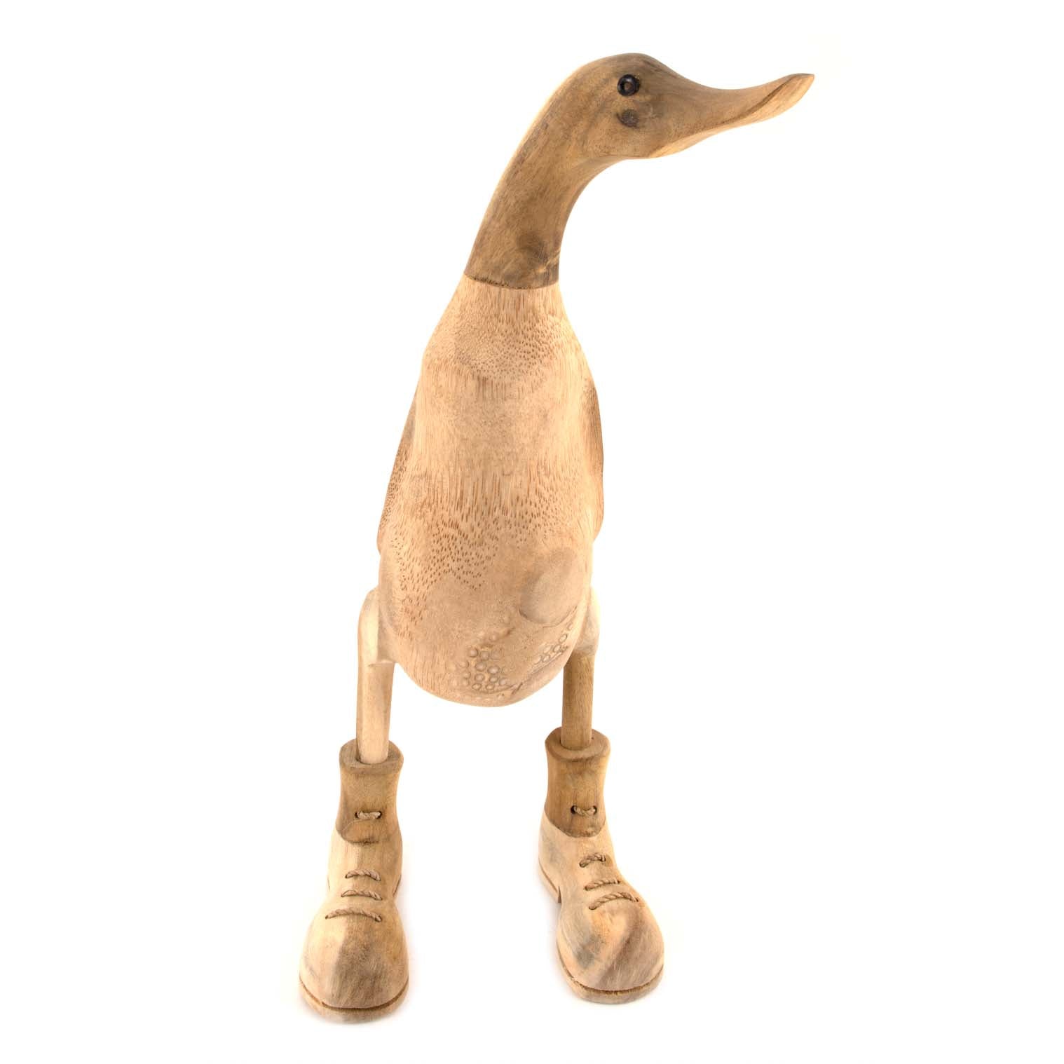 Front-on view of unfinished bamboo duck with carved boots, showing porous root body texture