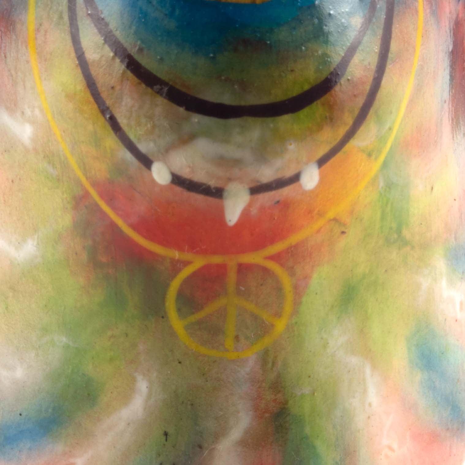 Detail of hand-painted peace symbol pendant on tie-dye bamboo duck body