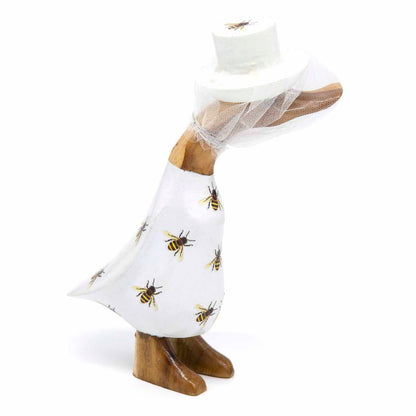 Side view of beekeeper bamboo duck with net veil falling over carved beak, white bee-print body