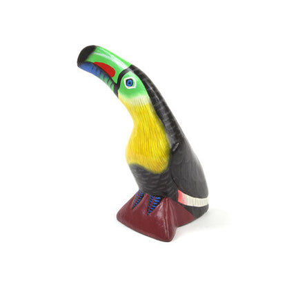 Painted wood toucan carving, three-quarter front view showing full bill and stump base