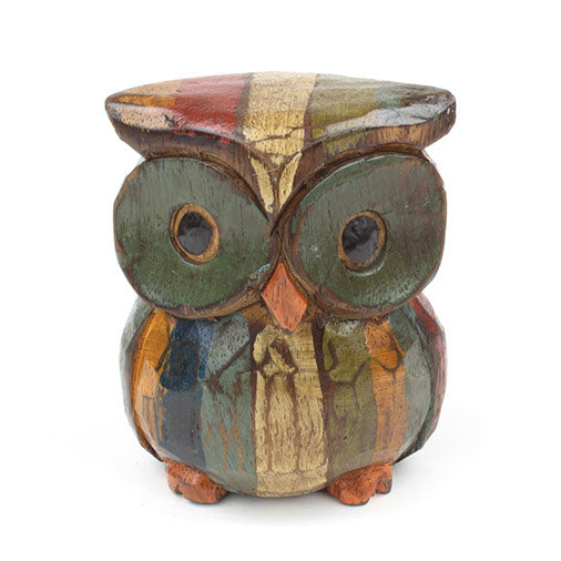 Close front view of large hand-painted Albizia owl showing green disc eyes and multicolour patchwork body, Bali
