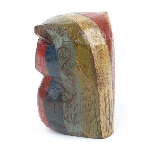 Side profile of small Albizia wood owl carving showing bark-textured paint and rounded body shape
