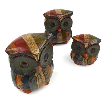 Three carved Albizia owls arranged together on white background showing varied sizes and distressed paint finish
