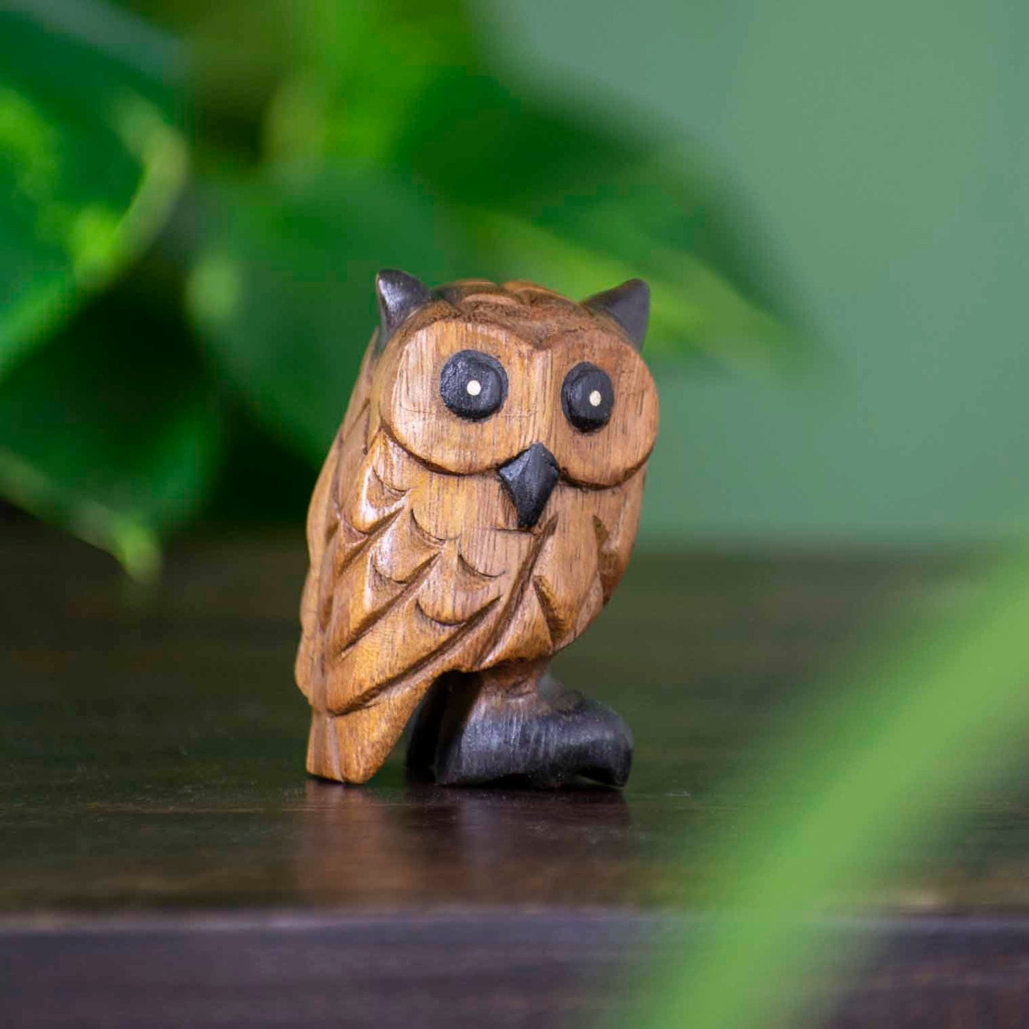 Small hand-carved acacia wood owl figurine with dark-stained eyes and beak, northern Thailand, front three-quarter view on da