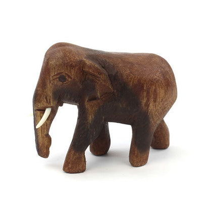 Carved wooden elephant figurine in Raintree, facing left, showing ear and body grain detail