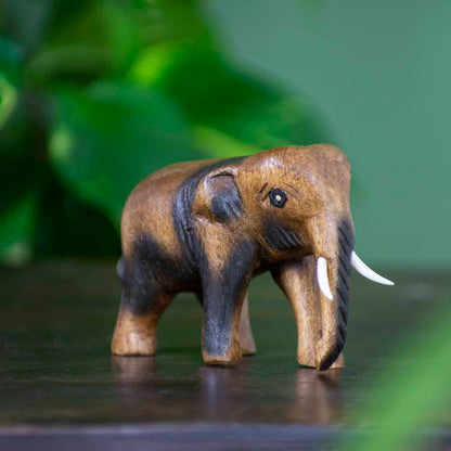 Small hand-carved Raintree elephant figurine with dark-stained detail, side view, northern Thailand