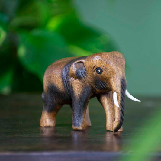 Small hand-carved Raintree elephant figurine with dark-stained detail, side view, northern Thailand