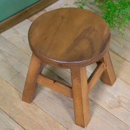 Plain Raintree wood stool with round seat and four splayed legs, warm grain visible, northern Thailand