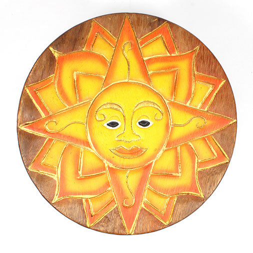Top-down view of carved sun face stool seat showing full ray pattern and painted face detail in Raintree wood