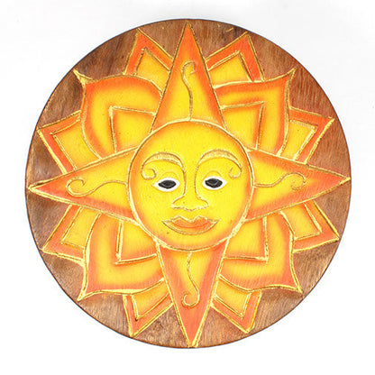 Top-down view of carved sun face stool seat showing full ray pattern and painted face detail in Raintree wood