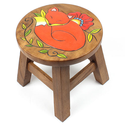 Hand-carved sleeping fox stool in Raintree wood, three-quarter view on white background showing leaf and flower border detail