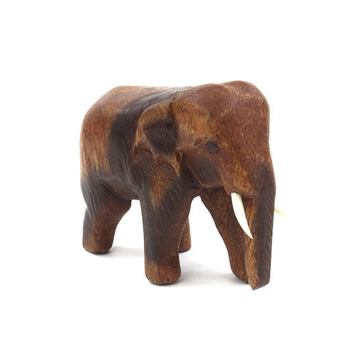 Small carved Raintree wood elephant, three-quarter front view on white background, Thailand