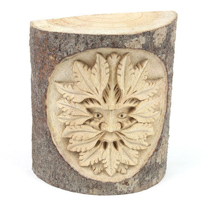 Front view of Green Man trunk carving on white background, pale white wood with leaf relief and natural bark edges