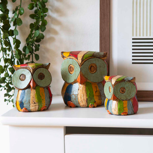 Set of three hand-painted Albizia wood owls in multicolour distressed finish, displayed on white shelf, Bali Indonesia