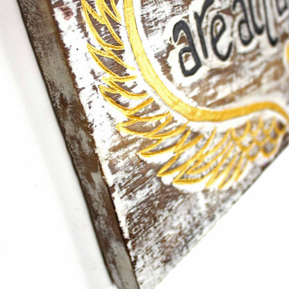 Side-angle detail of carved wood plaque showing depth of relief carving and whitewashed edge finish