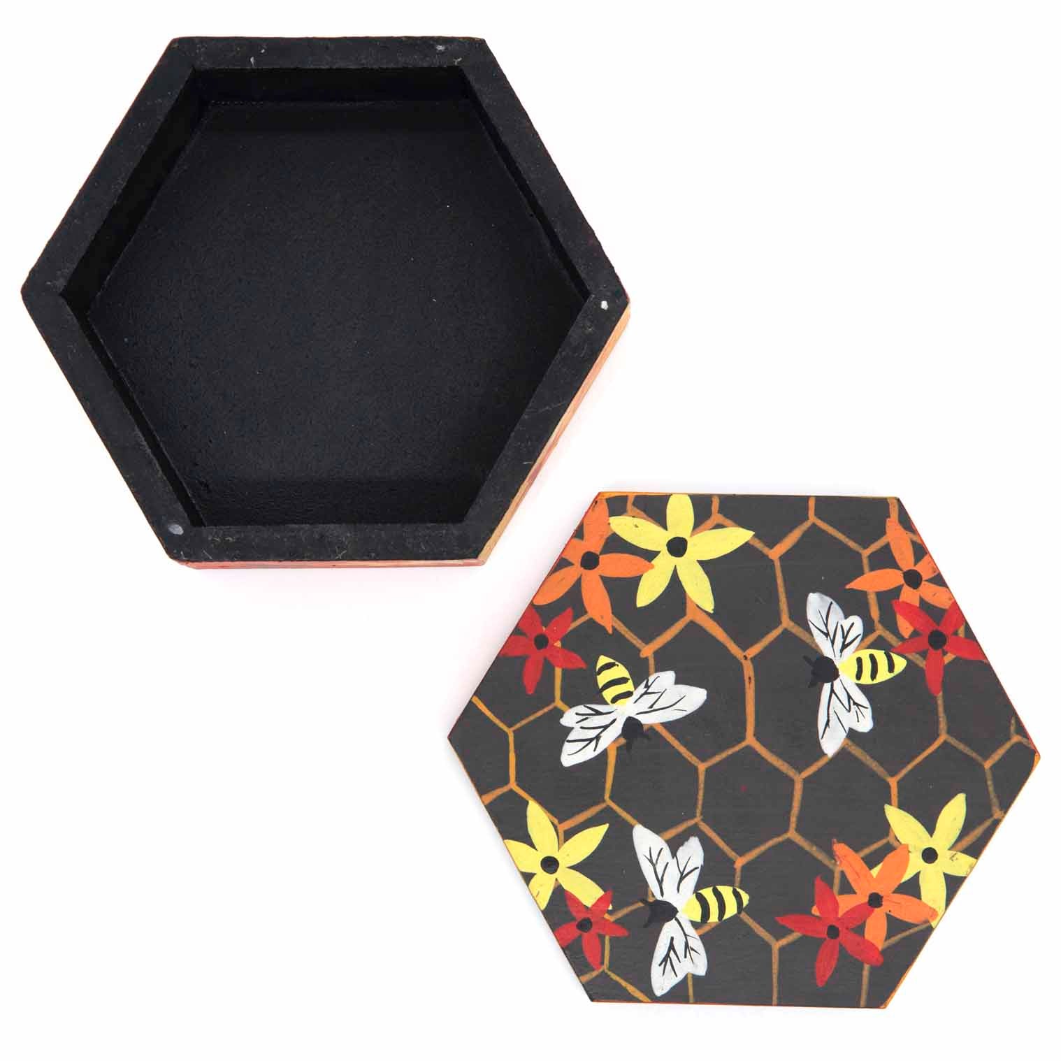 Top-down view of hexagonal bee box base and lid separated, showing honeycomb and bee pattern