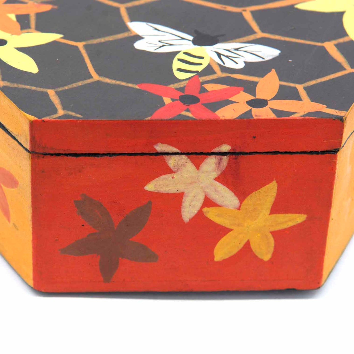 Side view of hexagonal bee box showing red and amber painted base with flower motifs, Indonesia