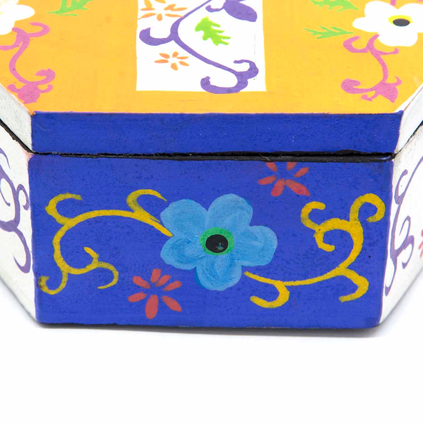 Side view of hexagonal cross box showing cobalt blue base with painted flower and vine motifs, Indonesia