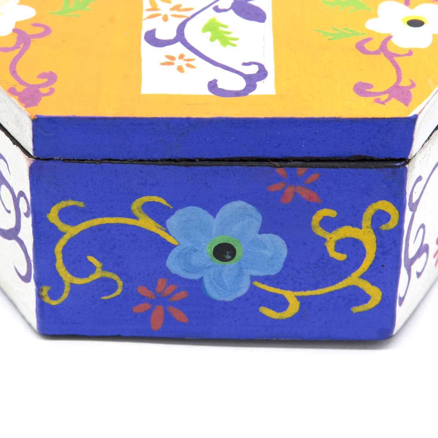 Side view of hexagonal cross box showing cobalt blue base with painted flower and vine motifs, Indonesia