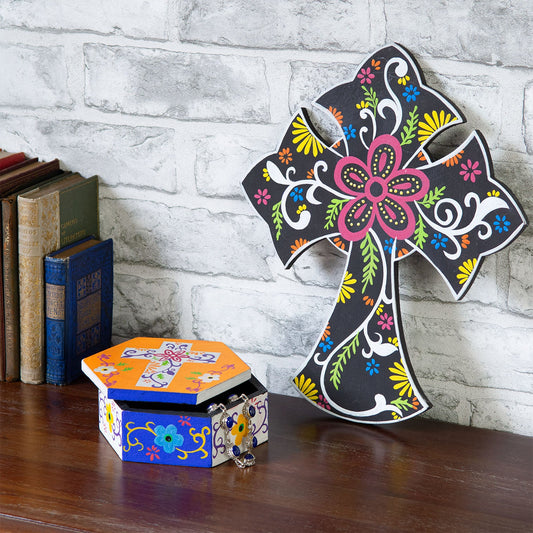 Hexagonal cross box and painted wooden cross displayed on a shelf beside books, Indonesia