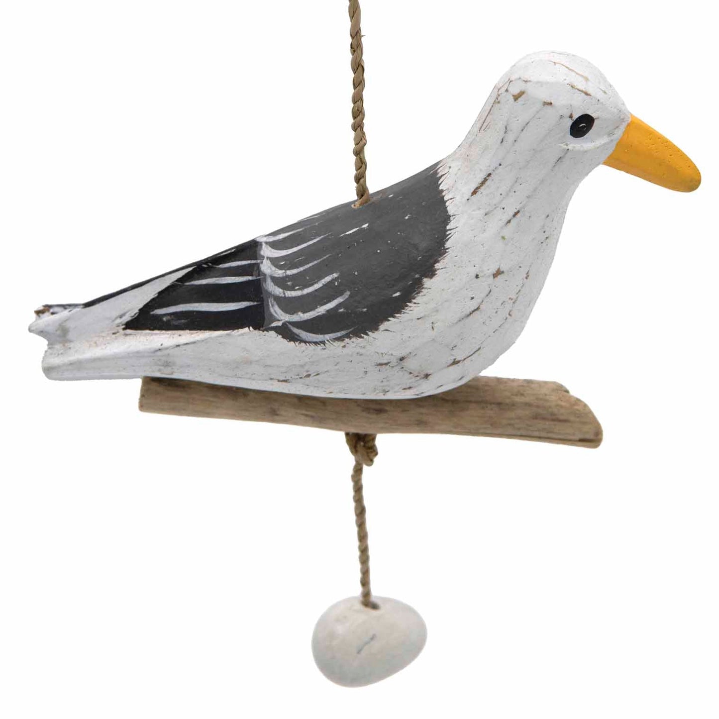 Close-up of hand-painted wooden seagull, white and grey with yellow bill, on driftwood perch