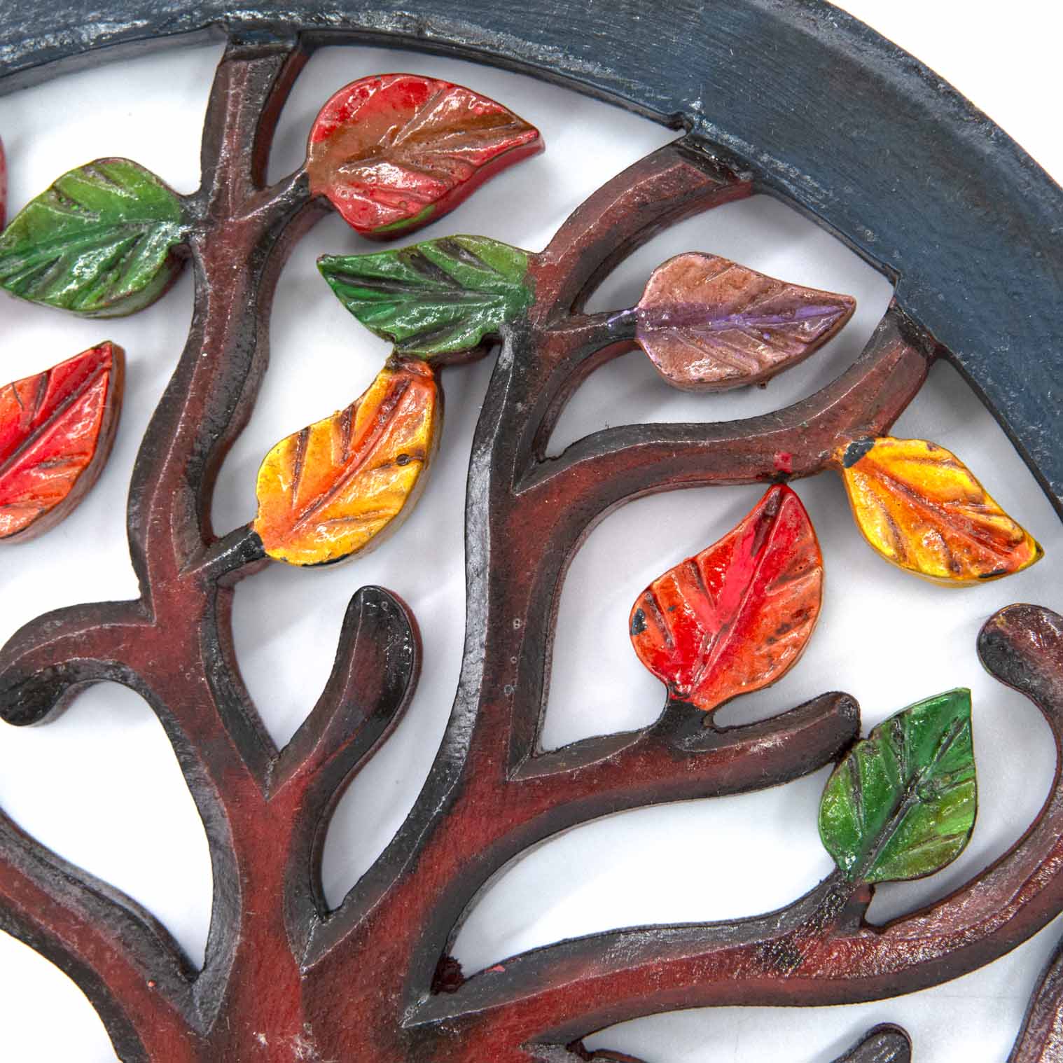 Close-up of hand-painted autumn leaves on Indonesian wood Tree of Life plaque, showing red, orange, amber and green tones
