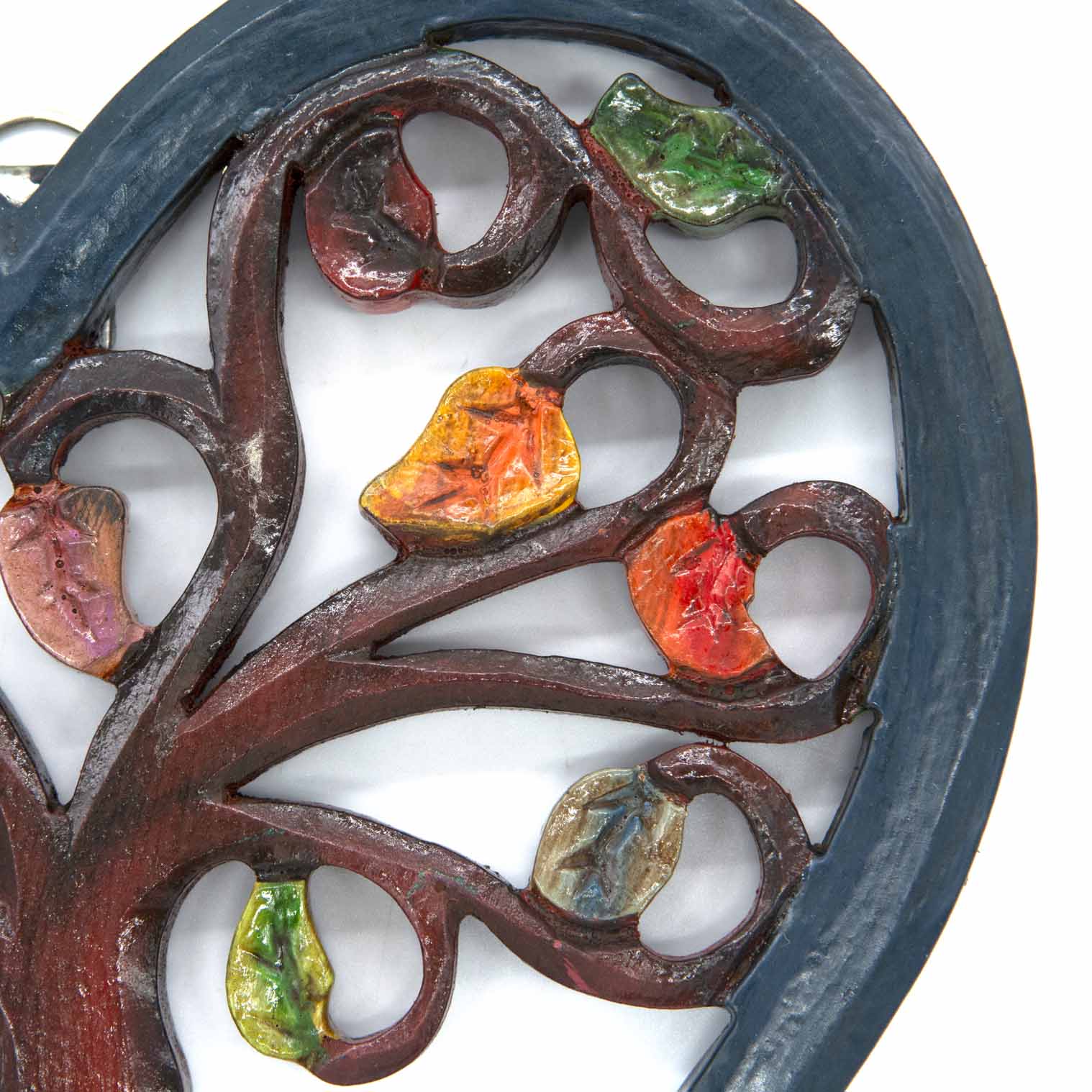 Close-up of upper branches on heart-shaped Tree of Life plaque showing red, orange and green hand-painted leaves, Indonesia