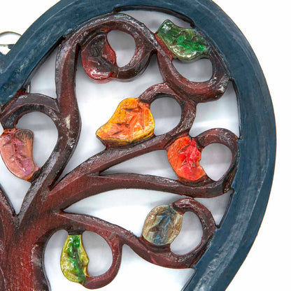 Close-up of upper branches on heart-shaped Tree of Life plaque showing red, orange and green hand-painted leaves, Indonesia